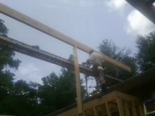 Carpenter setting a ridge beam over a new addition frame — Ice Dam Removal by Roofing Brothers in Saint Helena